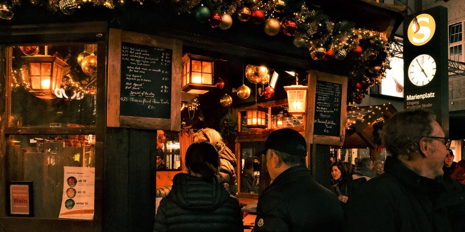 Sfeervolle kerstkraam met lampjes, kerstversiering en warme dranken