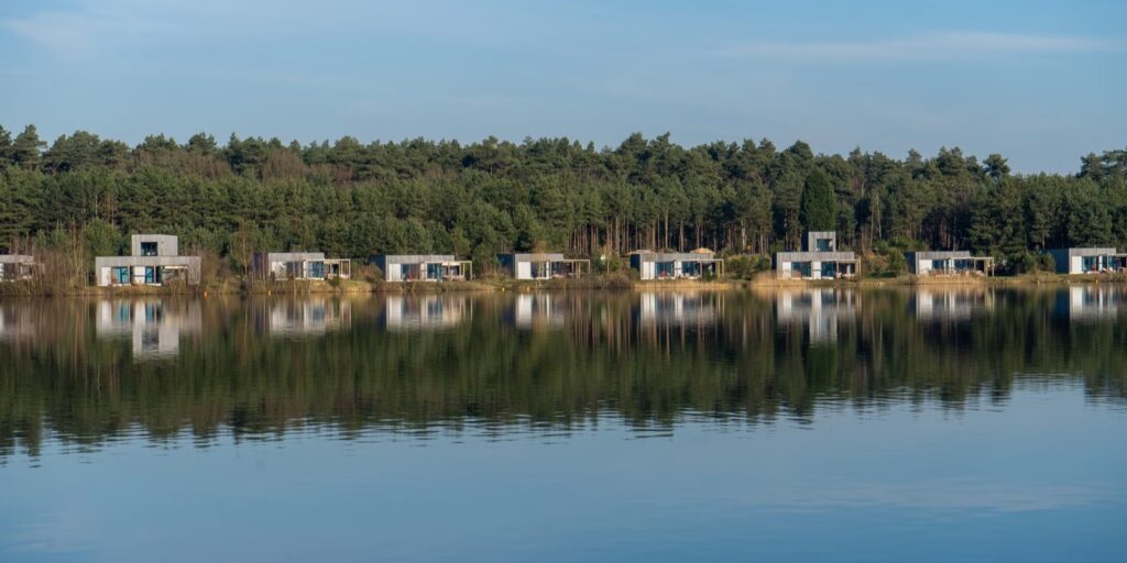 Vakantiehuisjes weerspiegeld in een meer bij een vakantiepark